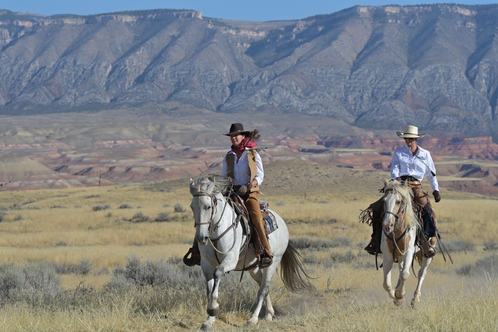Riders galloping across stunning Wyoming wilderness