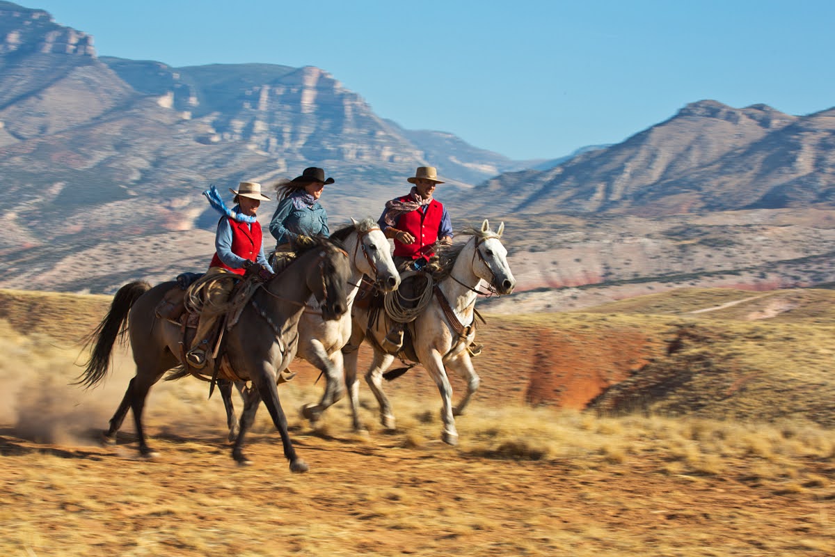 Riders galloping across stunning Wyoming wilderness