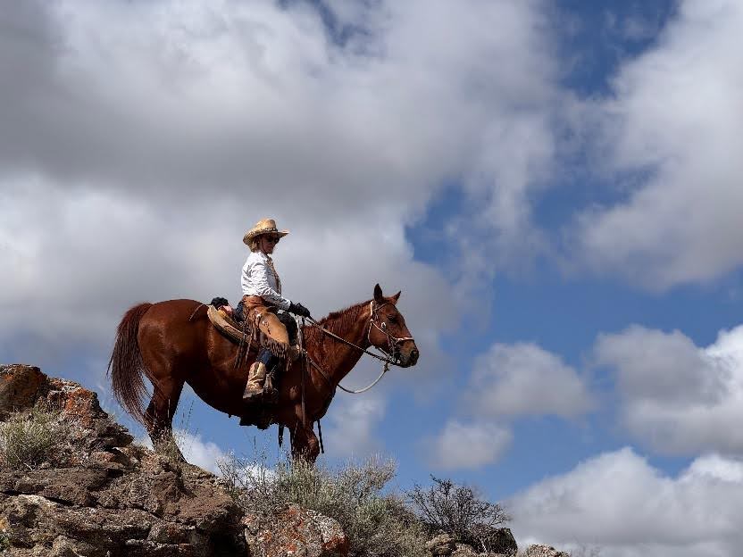 Riders galloping across stunning Wyoming wilderness