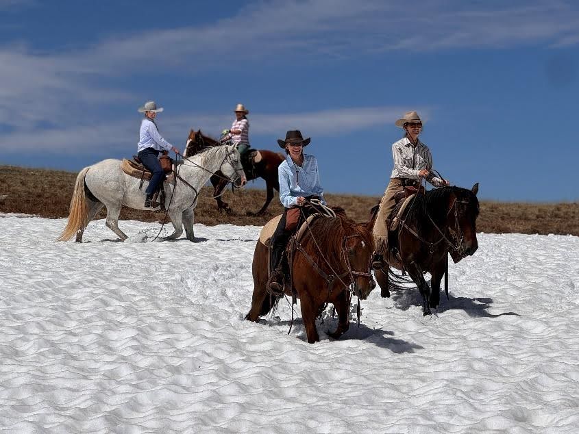 Riders galloping across stunning Wyoming wilderness